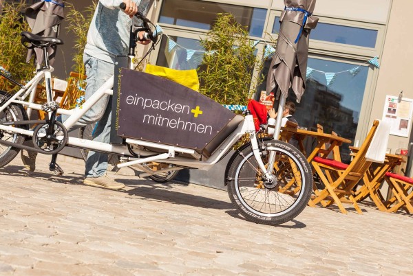 Man pushing a cargo bike at aspern Seestadt