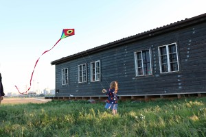 Notgalerie, ein Mädchen lässt einen Drachen steigen. Im Hintergrund: Die Kräne im Seeparkquartier.